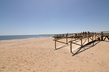 Fototapeta na wymiar A wooden walkway, on the beach of Isla Cristina, Spain. Widely used by vacationers on vacation.