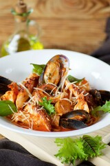 Seafood pasta - shrimp, clams and octopus served with cheese and basil leaves and red sauce