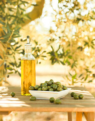 green olives and oil on table in olive grove