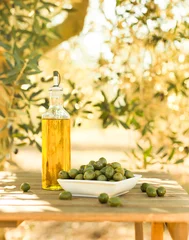 Tuinposter green olives and oil on table in olive grove © caftor
