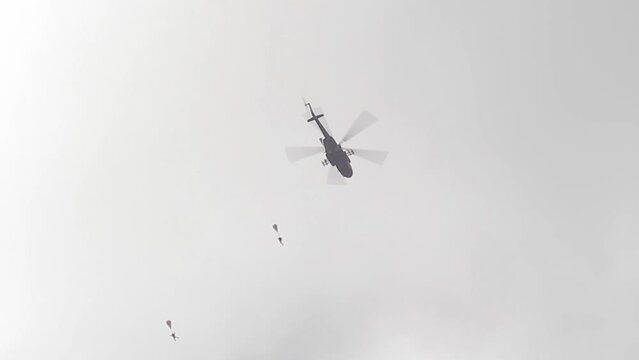 A Russian military helicopter dropping a parachute landing.
