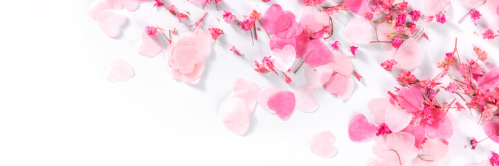 Valentine day panorama with pink hearts and flowers confetti, a flat lay panoramic banner on a white background with a place for text