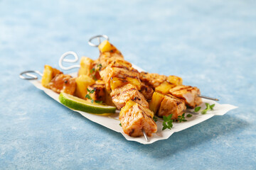 Grilled shashlik with salmon and pineapple. Served on paper try.