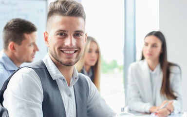 Businessman with colleagues in the background in office.