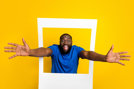 Portrait Of Handsome Trendy Crazy Cheerful Guy Coming Out Of Photo Frame Hug You Isolated Over Bright Yellow Color Background