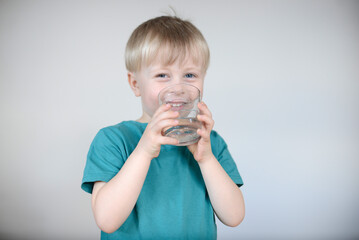 little blond boy drinks water