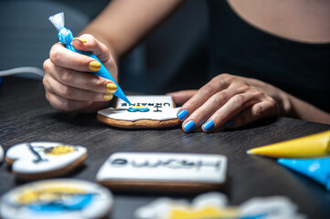 A woman makes patriotic gingerbread in support of Ukraine.