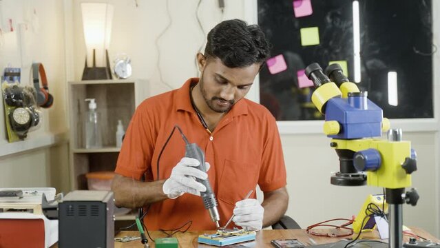 hand held shot of shocked repairman while reparing mobile phone circuit board at shop - concept of failure, crisis and mistake