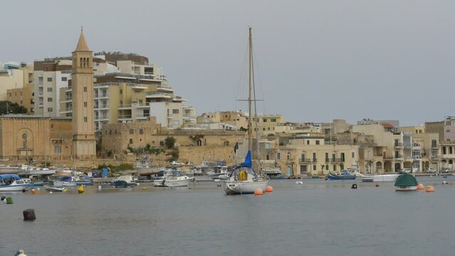 brightly painted boats with Marsaskala church, Malta