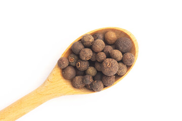Spice Allspice in yellow wooden spoon on white background. Macro. Healthy diet concept