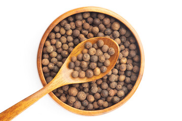 Spice Allspice in wooden bowl and spoon on white background. Flat lay. Brown color. Indian cuisine concept