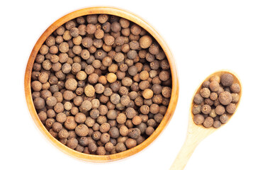 Spice Allspice (Jamaica pepper, Pimento) in wooden spoon and bowl on white background. Flat lay. Indian cuisine concept