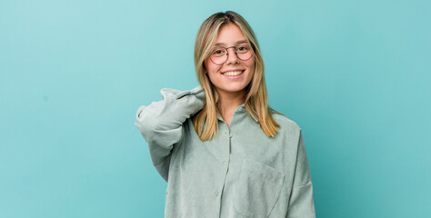 young pretty blonde woman laughing cheerfully and confidently with a casual, happy, friendly smile