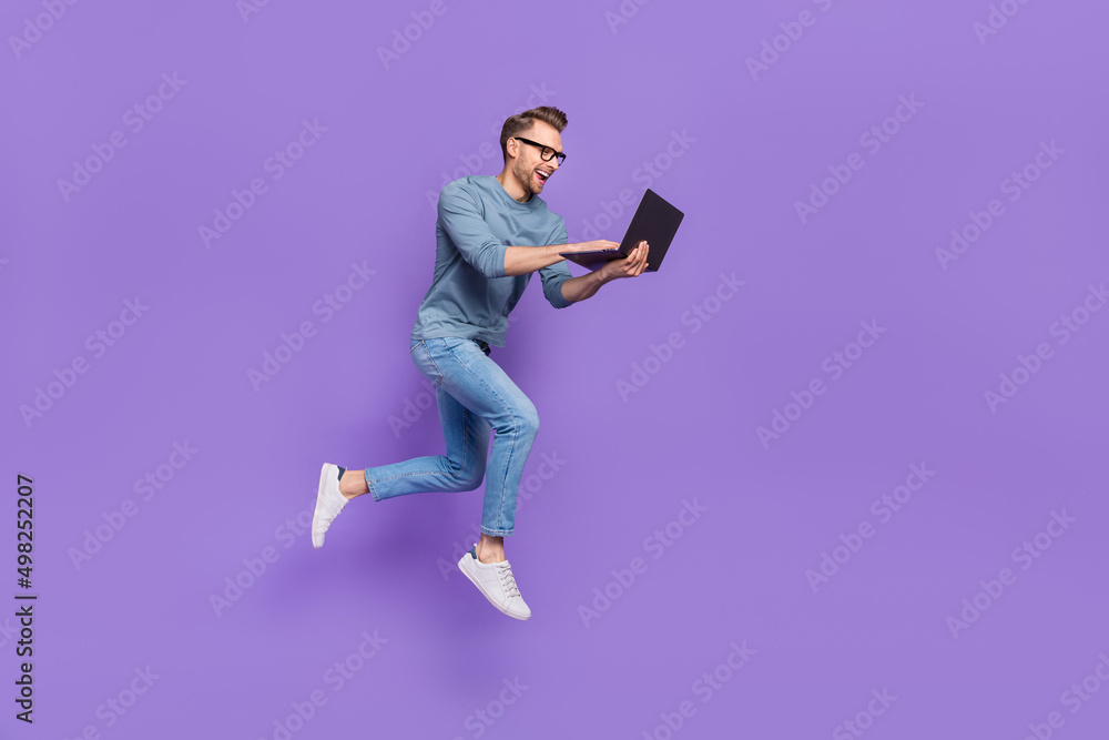 Sticker Photo of excited bust guy wear grey shirt spectacles jumping high typing modern device isolated violet color background