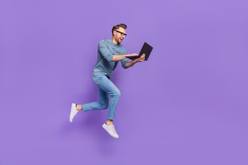 Photo of excited bust guy wear grey shirt spectacles jumping high typing modern device isolated...