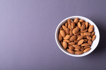 Directly above shot of almonds in bowl on gray background with copy space