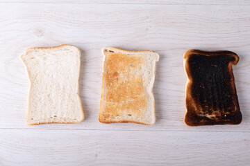 Directly above shot of toasted and burnt bread slices arranged side by side on table