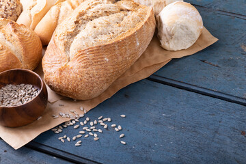 Close-up of various breads and seeds in bowl on brown wax paper at table