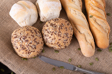 High angle close-up of buns and baguettes on jute fabric