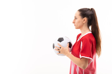 Side view of caucasian young female player with soccer ball standing against white background