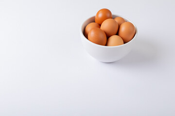 High angle view of brown eggs in bowl on table with blank space