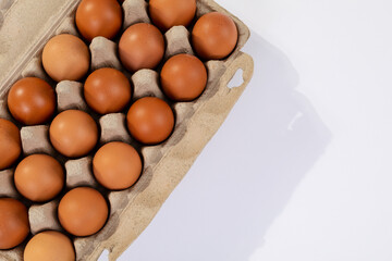 High angle view of brown eggs in egg carton on table with blank space