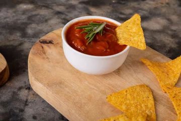 Foto op Plexiglas Close-up of nacho chips and red sauce with rosemary herb served on serving board at table © WavebreakMediaMicro