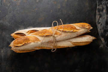 Overhead view of baguettes tied up with string on table