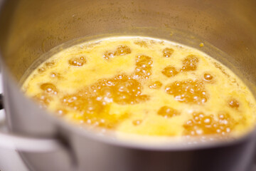 Orange jam boil in a saucepan. Bubbles in jam. Making jam at home. Orange confiture. Marmalade. Fruit jelly.