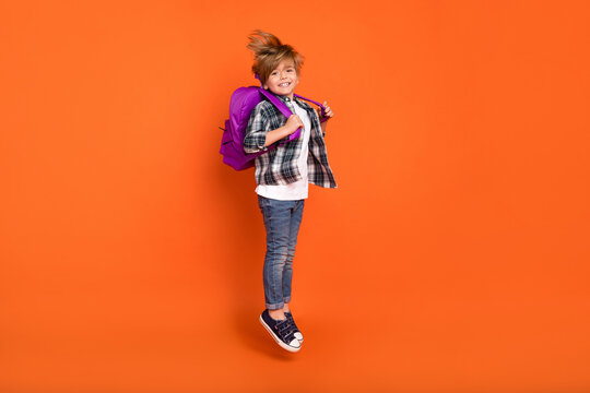 Full Body Profile Side Photo Of Young Boy Jump Hold Backpack Lesson Isolated Over Orange Color Background