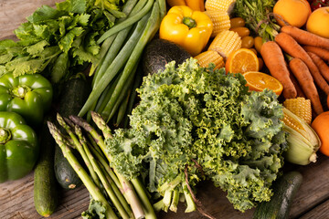 Various vegetables and fruits with kale, asparagus and zucchini on table