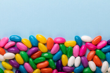 Overhead view of copy space and multi colored candies over blue background
