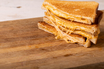Close-up stack of fresh cheese sandwich served on wooden serving board