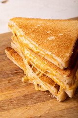 Close-up of fresh cheese sandwich stack on brown wooden serving board