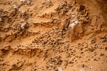 Textural sand, with  relief surface, multi-colored layers and different in size of granules, in outdoor sand career, after mining ore and sand for construction.