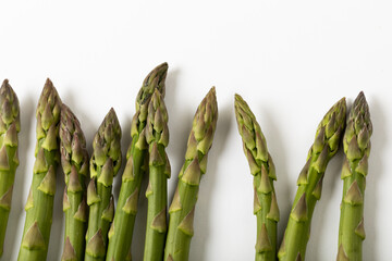 Overhead view of green raw asparagus against white background