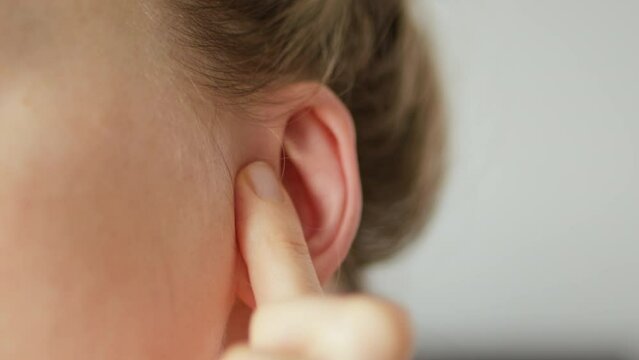Earache. Close-up of plugging ear, feeling painful discomfort and problem bad sound tinnitus or deafness. Otitis illness or other infectious diseases of the ears.