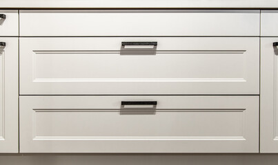 White kitchen cabinets with metal pulls or knobs on the doors.