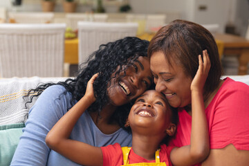 Happy african american girl with mother and grandmother at home