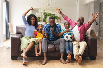 African american multi-generational family cheering while watching soccer match on tv - Powered by Adobe