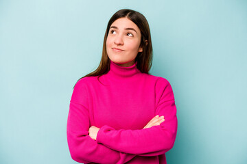 Young caucasian woman isolated on blue background dreaming of achieving goals and purposes