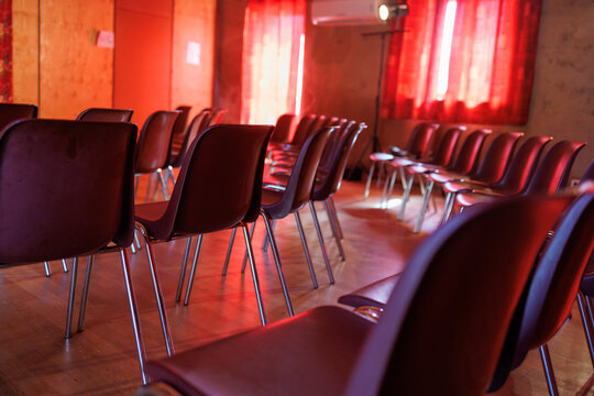 Many seats in a meeting room for an event with red ambiance