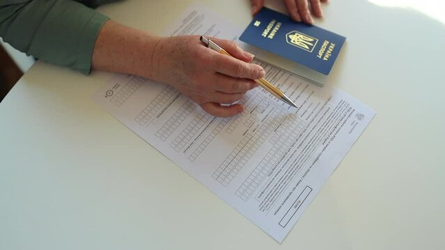 PESEL. National identification number in Poland. Polish ID. Official personal document.Woman hand write with a pen in PESEL document on white table