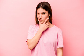 Young caucasian woman isolated on pink background contemplating, planning a strategy, thinking about the way of a business.