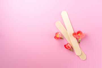 spatula for sugar depilation on a pink background, top view, spa