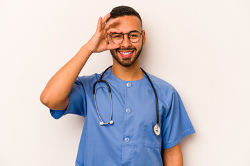Young hispanic nurse man isolated on white background excited keeping ok gesture on eye.