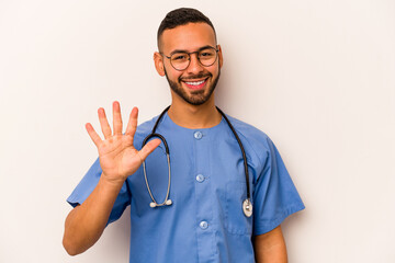 Young hispanic nurse man isolated on white background smiling cheerful showing number five with...