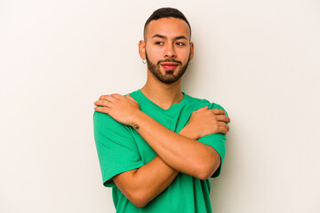 Young hispanic man isolated on white background hugs, smiling carefree and happy.