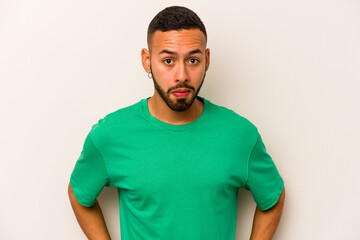 Young hispanic man isolated on white background confused, feels doubtful and unsure.