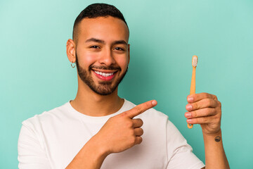 Young hispanic man wearing a toothbrush isolated on blue background